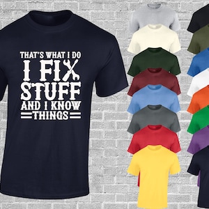 May include: A navy blue t-shirt with white text that reads "That's what I do I fix stuff and I know things". The text is accompanied by a graphic of two wrenches. The t-shirt is shown in a variety of colours.