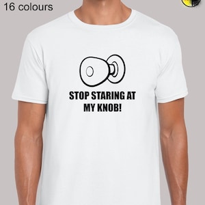 May include: White t-shirt with a black illustration of a door knob and the text "STOP STARING AT MY KNOB!"