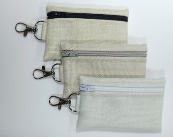 White/beige key ring pouch. Miniature pencil case. Wallet. Dog bag dispenser.