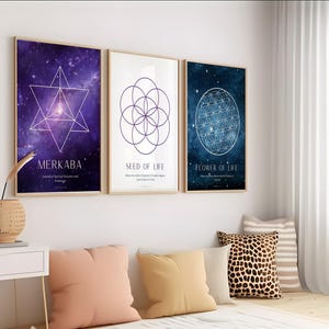 Op de afbeelding: Drie ingelijste prints met geometrische ontwerpen. De eerste print heeft een paarse en blauwe galactische achtergrond met een witte geometrische stervorm in het midden. De tweede print heeft een witte achtergrond met een paarse geometrische cirkel in het midden. De derde print heeft een blauwe galactische achtergrond met een witte geometrische cirkel in het midden. De prints zijn gelabeld met "Merkaba", "Zaad van het leven" en "Bloem van het leven".