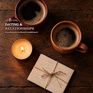 May include: A workbook titled DATING & RELATIONSHIPS: A communication workbook for AuDHD hearts, featuring two ceramic mugs filled with black coffee, a lit tea light candle, and a small, twine-tied envelope on a dark, rustic wooden surface.