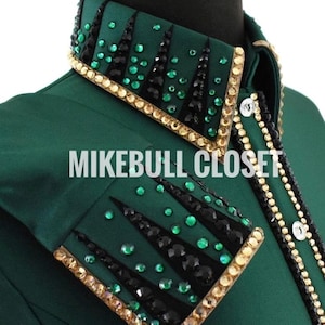 Puede incluir: Una camisa verde con un diseño de pedrería negra y verde en el cuello y el hombro. La camisa tiene un ribete dorado alrededor del diseño. El texto "MIKEBULL CLOSET" es visible en la camisa.
