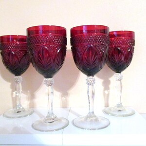 Puede incluir: Juego de cuatro copas de vino tinto con diseño de vidrio tallado. Las copas tienen un tallo y una base transparentes.