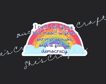 May include: A sticker with a rainbow design and the text "I can't tell if my bad mood is from perimenopause or the fall of democracy." The sticker has a black background and the words "She's Craft" in a cursive font.