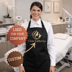 May include: A black apron with a gold logo that says "Glow Esthetics" and a pocket. The apron is worn over a white collared shirt. The image also includes text that says "LOGO FOR YOUR COMPANY" and "CUSTOM".