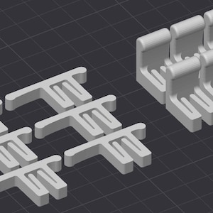 May include: A collection of light gray, three-dimensional plastic components featuring a T-shaped top bar and a series of parallel vertical fins. The set includes several flat-lying pieces and a group of upright, hook-shaped pieces arranged in rows.