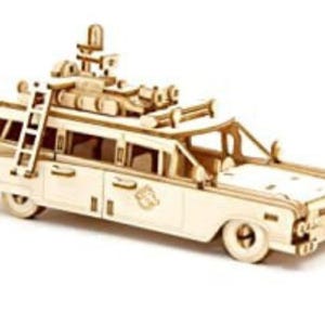 May include: A wooden model kit of the iconic Ghostbusters Ecto-1 car. The model features a detailed exterior with a ladder on the side and a variety of accessories on the roof.