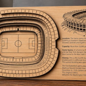 Puede incluir: Una placa rectangular de madera con un modelo 3D cortado con láser de Madison Square Garden. El lado izquierdo muestra las gradas y el campo, mientras que el lado derecho incluye una ilustración grabada y texto histórico sobre el recinto.