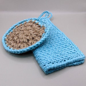 Può includere: Un set di due strofinacci all'uncinetto, uno blu e uno marrone. Lo strofinaccio blu ha un'ansa per appenderlo. Lo strofinaccio marrone è fatto di juta.