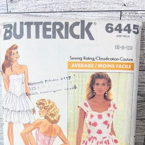 Peut inclure: Patron de couture Butterick 6445 avec des illustrations de robes. Le patron comprend une robe avec un nœud, une robe bustier et une robe à imprimé floral. La difficulté de couture est moyenne.