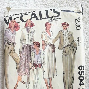 May include: Vintage McCall's sewing pattern envelope featuring illustrations of women's fashion designs. The envelope displays the McCall's logo, pattern number 6504, and size information. The designs include blazers, skirts, and dresses.