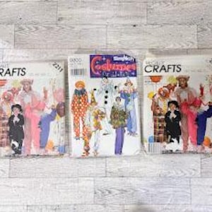Könnte beinhalten: Drei Papierschnittmuster-Umschläge für Kostüme. Zwei Umschläge sind mit McCall's Crafts 2211 beschriftet und zeigen Illustrationen von Clowns in bunten Outfits. Der mittlere Umschlag ist mit Simplicity Costumes 9800 beschriftet und zeigt verschiedene Clown-Designs.