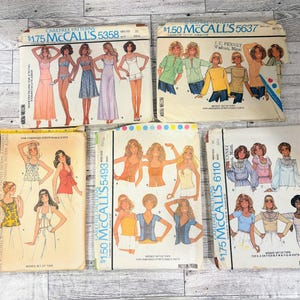 May include: Five vintage McCall's sewing pattern envelopes featuring illustrations of various tops, skirts, and dresses. The envelopes are labelled with pattern numbers 5358, 5637, 4110, 5493, and 6110, displaying prices ranging from $1.00 to $1.75.