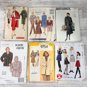 Può includere: Una collezione di sei cartamodelli vintage di marchi come Simplicity, McCall's, Butterick e Kwik-Sew. Le buste di carta presentano illustrazioni di vari capi come cappotti, gonne, giacche e abiti con testo stampato.