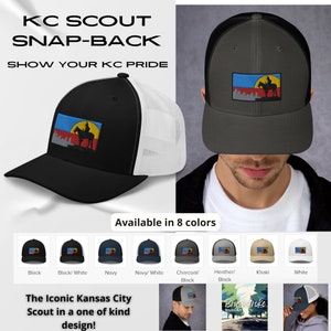May include: A black and white baseball cap with a mesh back. The front of the cap features a colorful embroidered patch with a silhouette of a person riding a horse. The text "KC SCOUT SNAP-BACK SHOW YOUR KC PRIDE" is displayed above the cap. The cap is available in eight colors.