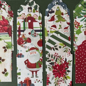 May include: Four decorative Christmas gift tags with scalloped edges. The tags feature festive designs including poinsettias, Santa Claus, snowmen, and Christmas trees. The tags are made of paper and have a hole at the top for attaching to gifts.