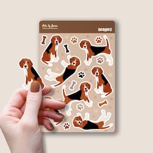 May include: A sheet of stickers featuring Beagle dogs in various poses. The stickers are on a brown background with white paw prints, bones, and hearts. The text "Beagles" is at the top of the sheet.
