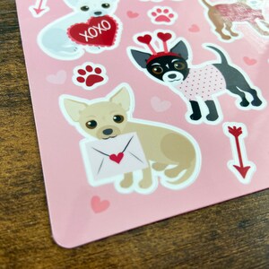 K&ouml;nnte beinhalten: Rosa Blatt mit Aufklebern, die verschiedene Illustrationen von Chihuahuas in verschiedenen Posen zeigen. Einige Aufkleber haben Herzen, Pfotenabdr&uuml;cke und Pfeile. Ein Aufkleber hat den Text "XOXO".
