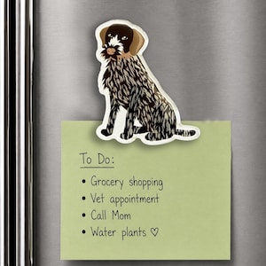 May include: A decorative magnet shaped like a German Wirehaired Pointer dog with a brown head and a black and white speckled coat, holding a light green square note with the text To Do: Grocery shopping, Vet appointment, Call Mom, Water plants.