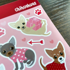 K&ouml;nnte beinhalten: Ein Bogen rosa Sticker mit verschiedenen Illustrationen von Chihuahuas. Die Sticker zeigen einen Chihuahua, der einen Stapel rosa Geschenkboxen tr&auml;gt, einen Chihuahua, der einen rosa-wei&szlig;en Pullover tr&auml;gt, und einen Chihuahua, der einen rot-wei&szlig;en Tupfenpullover tr&auml;gt.
