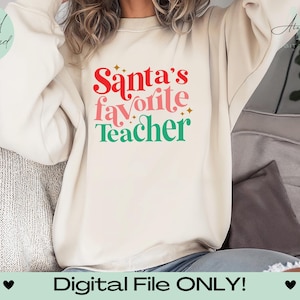 May include: A white sweatshirt with the text "Santa's favorite Teacher" in red, pink, and green lettering with gold glitter accents.