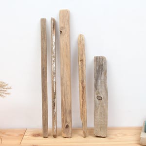 Può includere: Cinque pezzi di legno di deriva di diverse lunghezze e spessori. Il legno di deriva è di colore marrone chiaro e ha un aspetto naturale e invecchiato.