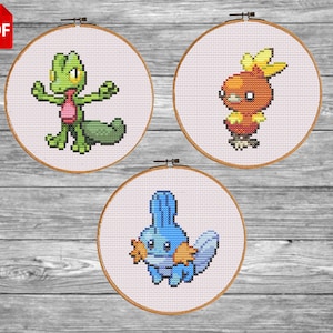 Może przedstawiać: Trzy tamborki do haftu krzyżykowego z kolorowymi postaciami z kreskówek. Postacie to zielona jaszczurka, pomarańczowy ptak i niebieskie stworzenie. Każdy wzór jest umieszczony na białym tle i oprawiony w drewnianą obręcz. Ikona PDF znajduje się w lewym górnym rogu.