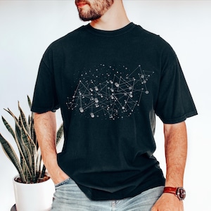 May include: Dark navy blue t-shirt featuring a white and gray geometric design of interconnected dots and lines. The short-sleeved shirt is made of a soft material and has a relaxed fit. The shirt is a casual wear item.