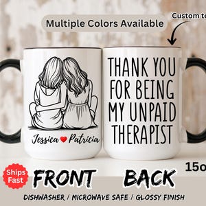 May include: White ceramic mug with a black handle and rim. The front features a black and white illustration of two women. The back of the mug says "THANK YOU FOR BEING MY UNPAID THERAPIST". The mug holds 15oz.