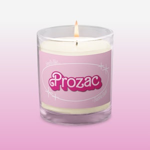 Puede incluir: Una vela rosa y blanca con el texto "Smells like... Prozac + Bubble Bath!" en la etiqueta.