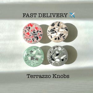 Pode incluir: Quatro botões redondos de terrazzo em diferentes combinações de cores. Os botões são vermelho e preto, bege e preto, verde e branco e cinza e branco.