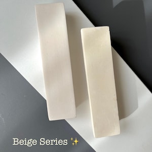May include: Two rectangular, beige-colored objects are displayed on a white and gray surface. The objects are positioned vertically, side by side. The text "Beige Series" is visible at the bottom of the image, with two gold star emojis.