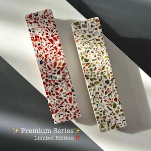 Op de afbeelding: Twee rechthoekige objecten in terrazzo-stijl met een witte basis. De ene heeft rode, witte en zwarte vlekken, de andere groene, bruine en witte vlekken. Tekst luidt "Premium Series Limited Edition !!"