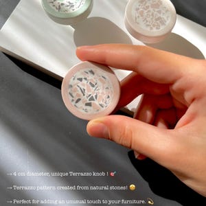May include: A set of three terrazzo knobs, one held in a hand, with a diameter of 4 cm. The knobs feature a unique terrazzo pattern created from natural stones. The text on the image says: "An original gift for your loved ones."