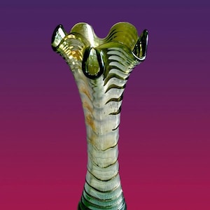 May include: A tall, clear glass vase with a wavy, ruffled top and a striped pattern in shades of green and white.