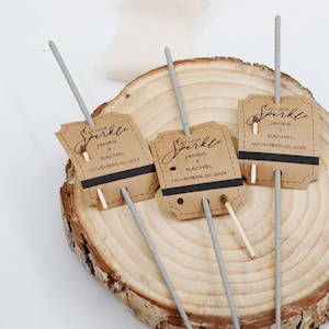 May include: Three silver sparklers with brown paper tags that say "Let Love Sparkle" with the names James and Rachel and the date November 20, 2024.