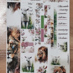 May include: A watercolor sticker sheet with a religious theme. The sheet features images of lions, lambs, and lilies. The sheet also includes a calendar with the days of the week and a list of tasks to complete. The text "Jesus said to her: I am the resurrection and the life. Whoever believes in me, though he die, yet shall he live. John 11:25" is printed on the sheet. The text "He is risen!" is also printed on the sheet.