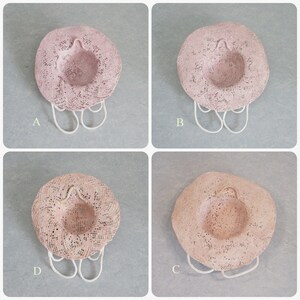 May include: Four pink straw hats with white trim and a white string handle. The hats are arranged in a grid pattern with the letters A, B, C, and D labeling each hat.
