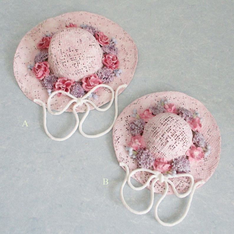 May include: Two pink straw hats with white ribbon ties and pink and purple flower embellishments. The hats are labeled A and B.