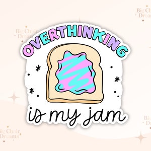 May include: A white sticker with a cartoon illustration of a slice of bread with pink and blue frosting. The text "OVERTHINKING is my jam" is written in a black cursive font.