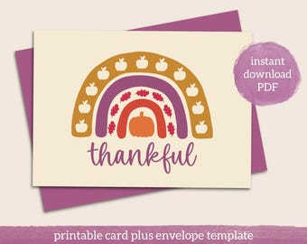 May include: A cream-colored card with a purple envelope features a fall-themed rainbow design. The rainbow includes a pumpkin, leaves, and apples, with the word "thankful" in a script font. The text "instant download PDF" is also visible.