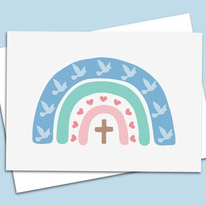May include: A greeting card featuring a colorful rainbow design. The rainbow includes blue, green, and pink arches, with doves, hearts, and a cross. The card is on a white background.