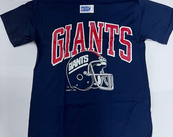 May include: A navy blue t-shirt with a red and white "Giants" logo and a white football helmet with the word "Giants" on the side. The text "TM LOGO 7, INC." is below the helmet.
