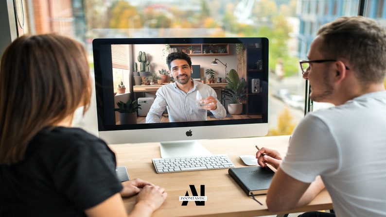 May include: Two people are having a video call on a computer. The person on the screen is holding a glass of water. The person on the left is looking at the screen, while the person on the right is looking at the screen and taking notes.