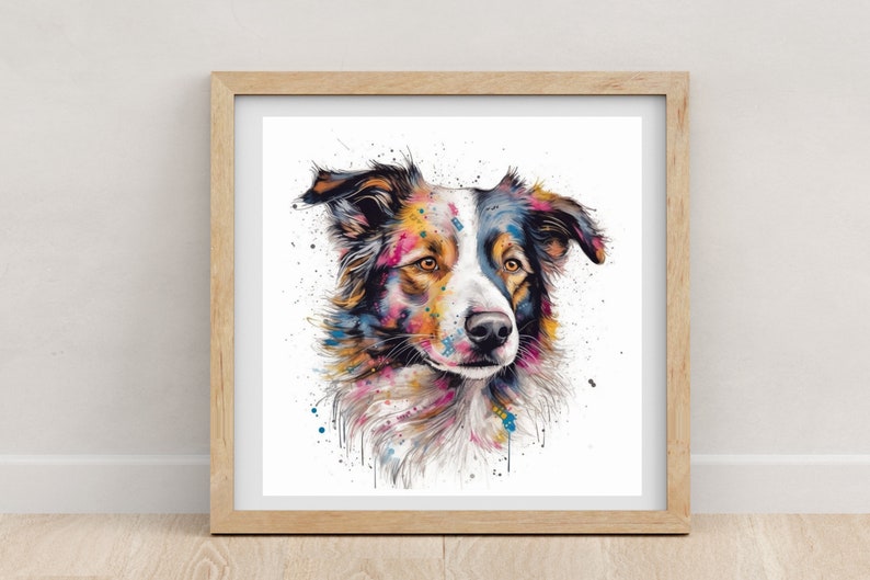 May include: A framed watercolor print of a Border Collie dog. The dog's fur is a mix of white, black, and brown, with colorful paint splatters in shades of pink, blue, yellow, and orange. The artwork is displayed in a light brown wooden frame.
