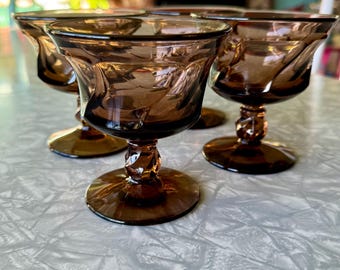 May include: Set of four brown glass stemmed dessert dishes with a twisted stem design.