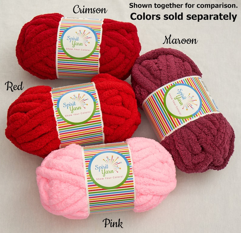 May include: Four skeins of yarn in different colors: red, crimson, maroon, and pink. Each skein has a label that says "Spirit Yarn" and "Show Your Colors!"