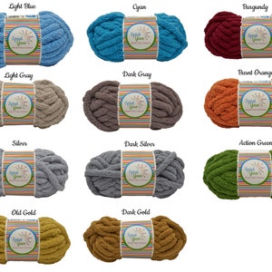 May include: A collection of 12 skeins of chunky yarn in various colors, including light blue, cyan, burgundy, light gray, dark gray, burnt orange, silver, dark silver, action green, old gold, and dark gold. Each skein has a label that reads "Spil Yarn".