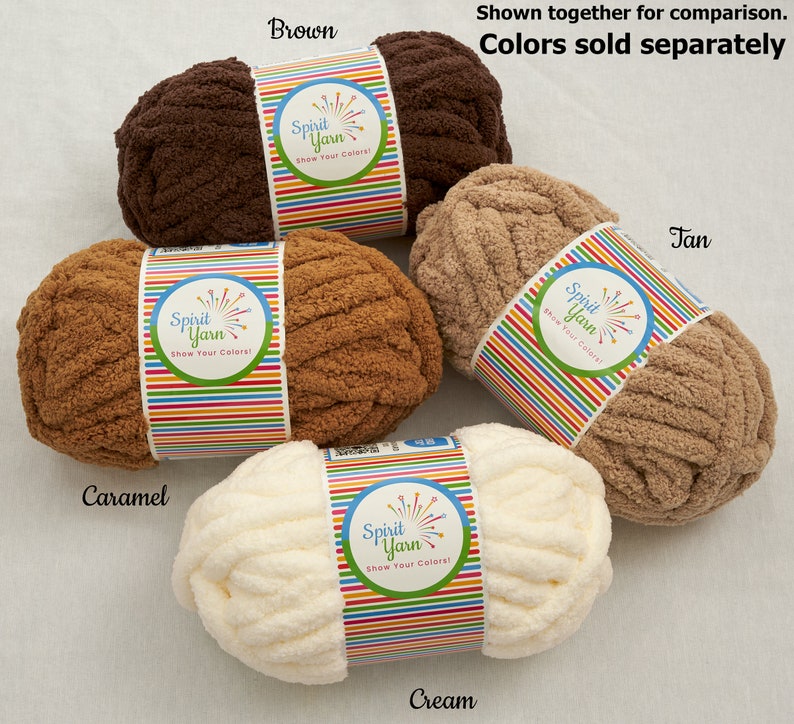 May include: Four skeins of Spirit Yarn in different colors: brown, caramel, cream, and tan. Each skein has a label with the Spirit Yarn logo and the text "Show Your Colors!"