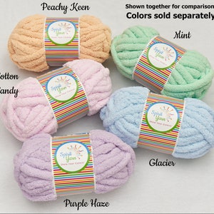 May include: Five skeins of soft, chunky yarn in various pastel colors: peach, pink, light blue, lavender, and mint. Each skein has a label that reads "Spirit Yarn Show Your Colors!" The colors are labeled "Peachy Keen", "Cotton Candy", "Glacier", "Purple Haze", and "Mint".